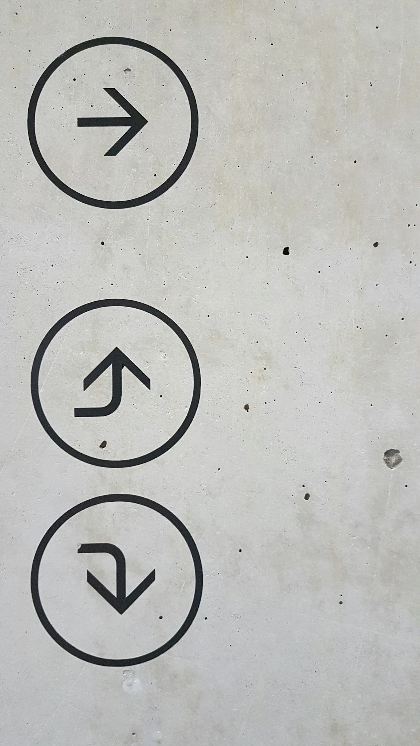 an up and down arrow on a concrete wall